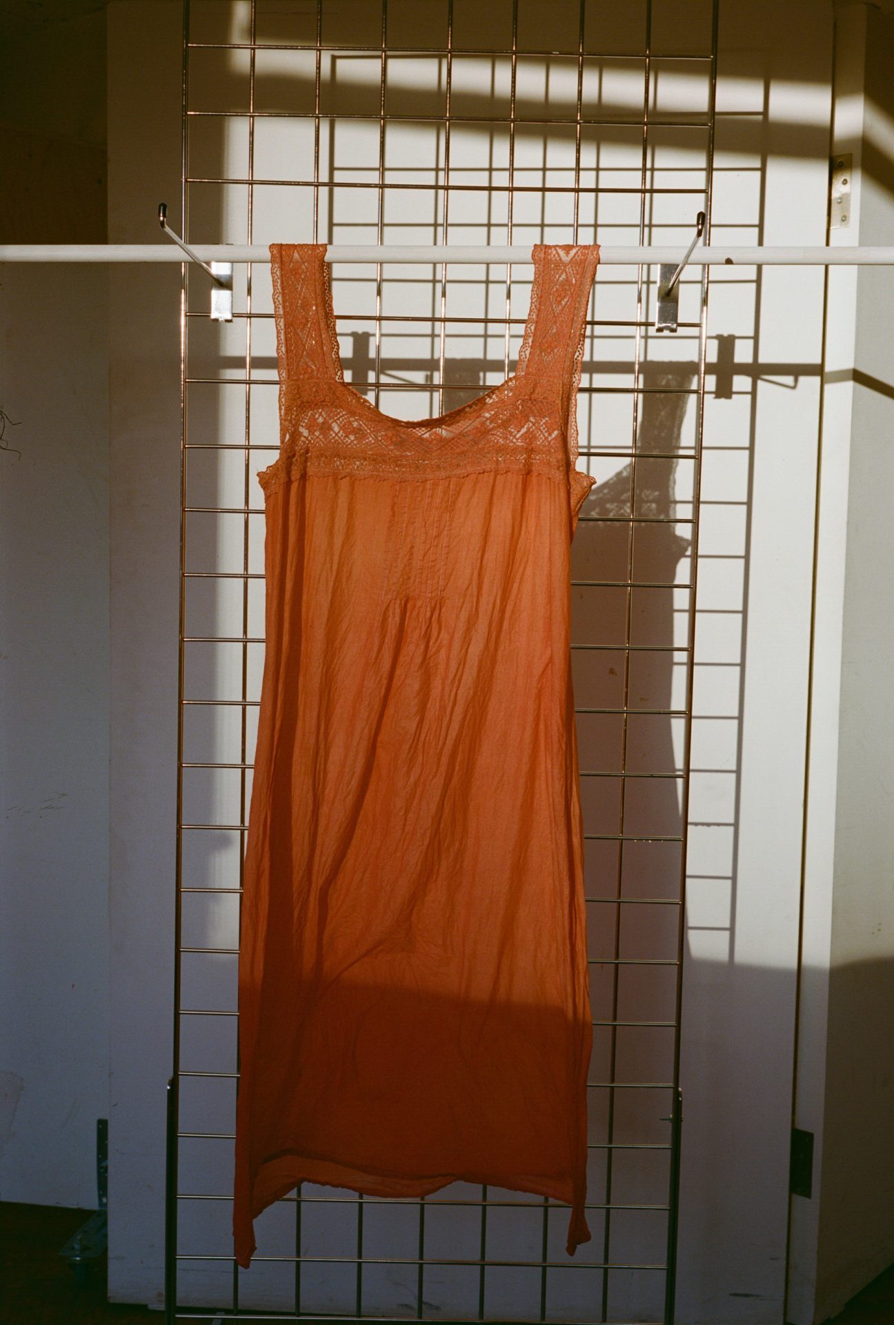 Petticoat dyed with madder hanging on a rail in sunlight.