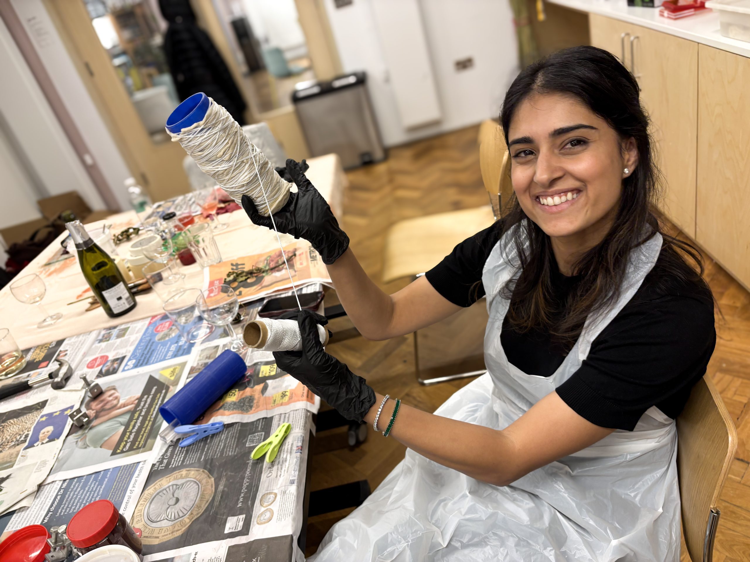 Participant at the London workshop holds fabric folded and bound for shibori dyeing technique